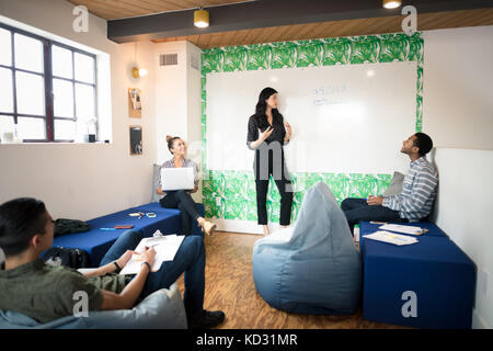 Junge Geschäftsfrau, die Whiteboard-präsentation in kreativen Tagungsraum Stockfoto