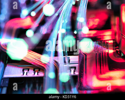 Glasfaserkabel übertragen Daten über elektronische Schaltkreise auf Laptop Stockfoto