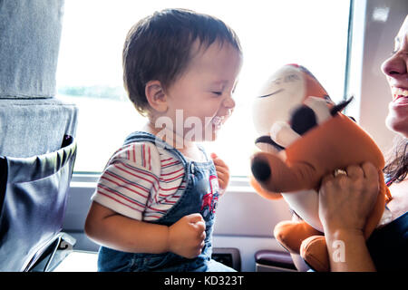 Mutter und Sohn Reisen im Zug, die gemeinsam spielen Stockfoto