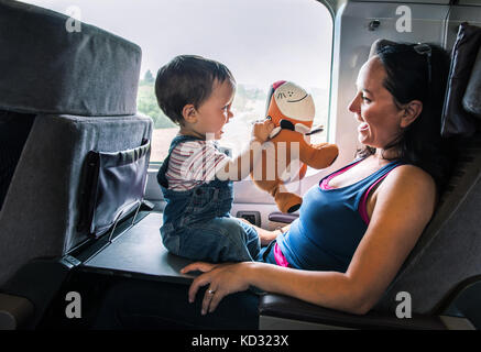 Mutter und Sohn Reisen im Zug, die gemeinsam spielen Stockfoto