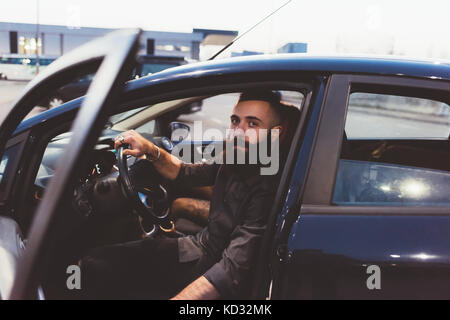 Bärtiger Mann im Auto an Kamera suchen Stockfoto