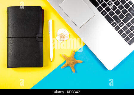 Urlaub, Reise Planung Konzept. Laptop - Notebook und Muscheln und Seesterne in blauen und gelben Hintergrund. Stockfoto