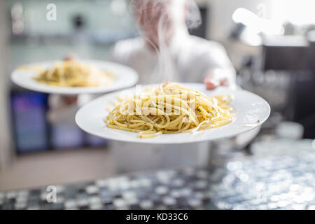 Koch Holding zubereitete Mahlzeiten, mittlere Partie Stockfoto