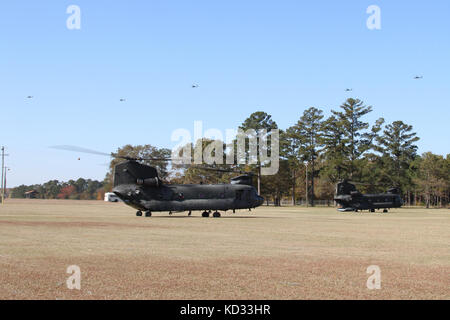 Die Kreide von AH-64D Apache longbow Hubschrauber vom 1 Bataillon, 151 Angriff reconnaissance Bataillon, von South Carolina Army National Guard und 1St Bataillon, 130 Angriff reconnaissance Bataillon, von der North Carolina Army National Guard, fliegen über zwei CH-47 Chinook aus der zweiten Bataillon, 151 Sicherheit und Unterstützung aviation Battalion nov. 15, 2014, während Carolina Thunder 2014 mcentire joint National Guard base statt. South Carolina National Guard, zusammen mit North Carolina und Georgia National Guard Einheiten durchgeführt Carolina Thunder 14, eine Bohrmaschine Wochenende, gemeinsame Ausbildung Übung Stockfoto
