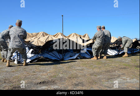 Mitglieder der 228. Theater Tactical Signal Brigade und des 2. Bataillons, 263. Luftverteidigungsartillerie arbeiten zusammen, um einen einsatzfähigen Rapid Assembly Shelter im Anderson County Sheriff's Office Training Center in Anderson, S.C., einzurichten. Als Teil von Vigilant Guard.Vigilant Guard ist eine Reihe von staatlich finanzierten Katastrophenhilfemaßungen, die von nationalen Garde-Einheiten durchgeführt werden, die mit Bundes-, Landes- und lokalen Notfallverwaltungsbehörden und Ersthelfern arbeiten. (USA Foto der Armee-Nationalgarde von 1. LT. Jessica Donnelly/veröffentlicht) Stockfoto