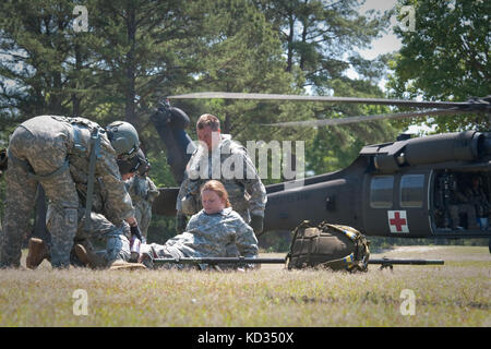 Spc. Chris Harrelson von Company A, 1-111. General Aviation Support Battalion, South Carolina Army National Guard, bereitet sich darauf vor, im Rahmen einer Personalwiederherstellung und einer Flugzeugschulung im McCrady Training Center, Eastover, S.C., 3. Mai 2015, einen Unfallopfer in ein nahegelegenes MEDEVAC zu verlegen. Die Schulung ermöglichte es den Besatzungen, Erfahrung und Vertrauen in die Verfahren zur Personalwiederherstellung in Verbindung mit der Ausführung von Aufgaben des Armeekriegers aufzubauen, um sicherzustellen, dass das Bataillon auf Situationen vorbereitet ist, die entweder aus CONUS- oder OCONUS-Bereitstellungen resultieren. (USA Foto der Armee-Nationalgarde von Sgt. Brian Calhoun/Relea Stockfoto