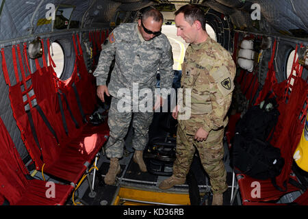 Us-Armee SPC. Ira Duville (links), ein Betreuer und Mannschaft Leiter mit der South Carolina Army National Guard's 2-238 th Allgemeine Unterstützung Aviation Battalion Loslösung 1, gibt einen Safety briefing zu Sgt. Jimmie Bischof, eine Crew Chief zu1-151 st Angriff Reconnaissance Bataillon zugeordnet, bevor eine Mission auf einer Boeing CH-47 Chinook hubschrauber McEntire Joint National Guard Base, S.C., während einer landesweiten Hochwasser-gefahrenstufen, Oktober 6, 2015. Das South Carolina National Guard wurde aktiviert und County Emergency Management Agenturen und lokalen Ersthelfer als historische Hochwasser Auswirkungen countie zu unterstützen. Stockfoto