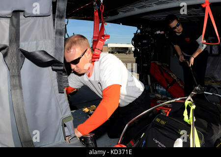 Emerson Kovalanchik, Links, und Jennifer Williams, rechts, sowohl Rettung von Technikern an der South Carolina Hubschrauber Aquatic Rescue Team zugeordnet sind, bereiten Sie ein Südcarolina nationale Schutz UH-60 Black Hawk hubschrauber McEntire Joint National Guard Base, S.C., für eine Aufklärungsmission während einer landesweiten Hochwasser-gefahrenstufen, Oktober 8, 2015. Das South Carolina National Guard wurde aktiviert und County Emergency Management Agenturen und lokalen Ersthelfer als historische Hochwasser zu unterstützen Auswirkungen Grafschaften national. Derzeit werden mehr als 2.600 Südcarolina Mitglieder des nationalen Schutzes haben. Stockfoto