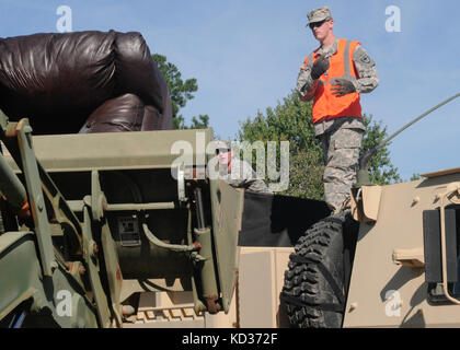 U.s. Army Staff Sgt. Michael Frau Sarkkinen und Sgt. Stephen Ross, der 1223Rd Engineering Company, South Carolina Army National Guard, einem Baggerlader von Staff Sgt Betrieben zugeordnet. Douglas brill Entfernen beschädigt Haushaltswaren von Residenzen durch Hochwasser in der Stadt von summerville Okt beschädigt. 8, 2015. die South Carolina National Guard mit Bundes-, Landes- und lokale Emergency Management Agenturen und Ersthelfer in Reaktion auf Hochwasser bedroht weite im Bereich zusammengeschlossen, um als Ergebnis der starken Regen. (U.s. Army National Guard Foto von Sgt. Kevin Pickering/freigegeben) Stockfoto