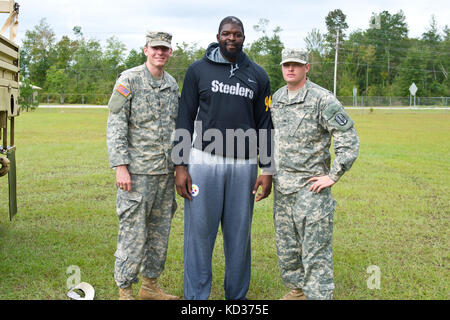 NFL-Spieler Clifton Geathers posiert für Fotos mit US-Soldaten, die der 1053. Transportation Company, South Carolina Army National Guard, zugewiesen wurden, als Dankeschön für die Hilfe, die sie bei der Wiederherstellung von Familiensachen aus ihrem überfluteten Haus in Brown's Ferry in der Nähe von Georgetown, South Carolina, 10. Oktober 2015. Die South Carolina National Guard wurde aktiviert, um staatliche und County Notfallmanagement-Agenturen und lokale Ersthelfer zu unterstützen, da historische Überschwemmungen Grafschaften landesweit beeinflussen. Derzeit wurden mehr als 3,000 Mitglieder der South Carolina National Guard als Reaktion auf die Überschwemmungen aktiviert. ( Stockfoto