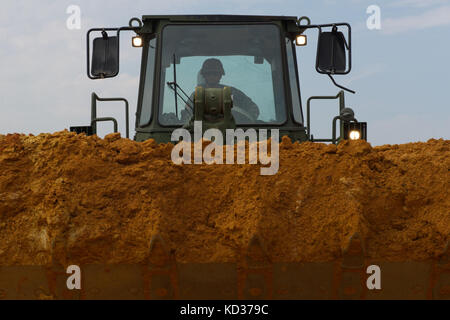 U.S. Army Sgt. Jeffery Bucknam, ein Schwerausrüstungsoperator bei der 124th Engineer Company für die South Carolina Army National Guard, fährt während des Straßenumbaus in Swansea, S.C., einen Frontlader voller Schmutz, während sich der Staat von den Überschwemmungen der letzten Wochen, 13. Oktober 2015, erholt. Die South Carolina National Guard wurde aktiviert, um staatliche und County Notfallmanagement-Agenturen und lokale Ersthelfer zu unterstützen, da historische Überschwemmungen Grafschaften landesweit betroffen. Derzeit wurden mehr als 2,200 Mitglieder der South Carolina National Guard als Reaktion auf die Überschwemmungen aktiviert. (USA Air Natio Stockfoto