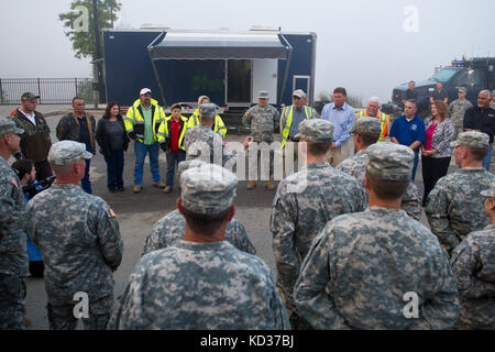 US Army Gen. Frank Grass, der Chef des National Guard Bureau, überreicht Münzen an die zivilen Auftragnehmer, die an der Reparatur des Flussuferkanals in Columbia, South Carolina, gearbeitet haben, 14. Oktober 2015. Die South Carolina National Guard wurde aktiviert, um staatliche und County Notfallmanagement-Agenturen und lokale Ersthelfer zu unterstützen, da historische Überschwemmungen Grafschaften landesweit betroffen. Derzeit wurden mehr als 2,200 Mitglieder der South Carolina National Guard als Reaktion auf die Überschwemmungen aktiviert. (USA Air National Guard Foto von Tech. Sgt. Jorge Intriago/Freigegeben) Stockfoto