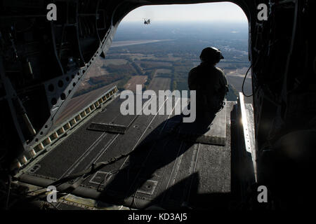 Us army CH-47 Chinook Mannschaft Leiter, die 2-151 st Sicherheit und Unterstützung aviation Battalion zugeordnet, South Carolina Army National Guard, sitzt auf der Kante des Chinook Heckklappe während Carolina Thunder 14, Sep. 15, 2014 South Carolina National Guard, zusammen mit North Carolina, Georgia und Tennessee National Guard Einheiten durchgeführt Carolina Thunder 14, eine gemeinsame Ausbildung Übung während der Bohrer Wochenende. mehr als 30 Flugzeuge nahmen an der Masse vom mcentire joint National Guard, der eastover, s.c. Einheiten in der Luft und am Boden bei den Savannah River site in Aiken, s.c. Stockfoto