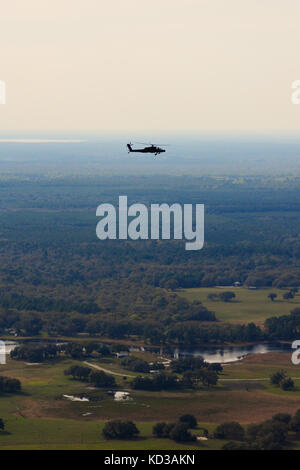 U.S. Army AH-64D Apache, der dem Angriffsaufklärungsbataillon 151, South Carolina Army National Guard, zugewiesen wurde, fliegt über die Naval Air Station Jacksonville, Florida, 11. März 2014. Die Apachen sind in Jacksonville, um mit dem U.S. Navy Helicopter Anti Submarine Squadron 11 in Anti-Oberflächen-Kriegsführung und Kampf Such-und Rettungsaktionen zu trainieren. (USA Air National Guard Foto von Tech. Sgt. Jorge Intriago/Freigegeben) Stockfoto