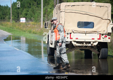 Us-Armee Sgt. brandon Stafford, und die 133 Military Police company in South Carolina Army National Guard bietet Hilfe und Traffic Control während einer Wiederherstellung des Fahrzeugs in Lee County, S.C. ÜLG zugewiesen. 6, 2015. die South Carolina National Guard mit Bundes-, Landes- und lokale Emergency Management Agenturen und Ersthelfer in Reaktion auf Hochwasser bedroht weite im Bereich zusammengeschlossen, um als Ergebnis der starken Regen. (U.s. Army National Guard Foto von Sgt. Brian Calhoun/freigegeben) Stockfoto