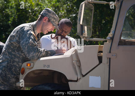 Us-Armee Sgt. brandon Stafford die 133 Military Police company in South Carolina Army National Guard bietet Unterstützung und Informationen zu David gipson von North Santee, s.c. während einer Gesundheit und Wohlfahrt prüfen 6. Oktober 2015. Die Gesundheit und das Wohlergehen der Kontrollen als Antwort auf weitverbreitete Überschwemmungen in der Region als Folge des schweren Regens waren. Die South Carolina National Guard mit Bundes-, Landes- und lokale Emergency Management Agenturen und Ersthelfern zusammengeschlossen. (U.s. Army National Guard Foto von Sgt. Brian Calhoun/freigegeben) Stockfoto