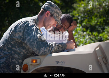 Us-Armee Sgt. brandon Stafford die 133 Military Police company in South Carolina Army National Guard bietet Unterstützung und Informationen zu David gipson von North Santee, s.c. während einer Gesundheit und Wohlfahrt prüfen 6. Oktober 2015. Die Gesundheit und das Wohlergehen der Kontrollen als Antwort auf weitverbreitete Überschwemmungen in der Region als Folge des schweren Regens waren. Die South Carolina National Guard mit Bundes-, Landes- und lokale Emergency Management Agenturen und Ersthelfern zusammengeschlossen. (U.s. Army National Guard Foto von Sgt. Brian Calhoun/freigegeben) Stockfoto