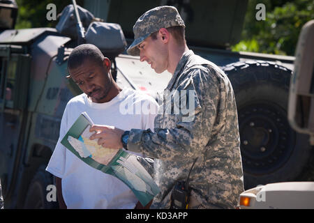 Us-Armee Sgt. brandon Stafford die 133 Military Police company in South Carolina Army National Guard bietet Unterstützung und Informationen zu David gipson von North Santee, s.c. während einer Gesundheit und Wohlfahrt prüfen 6. Oktober 2015. Die Gesundheit und das Wohlergehen der Kontrollen als Antwort auf weitverbreitete Überschwemmungen in der Region als Folge des schweren Regens waren. Die South Carolina National Guard mit Bundes-, Landes- und lokale Emergency Management Agenturen und Ersthelfern zusammengeschlossen. (U.s. Army National Guard Foto von Sgt. Brian Calhoun/freigegeben) Stockfoto