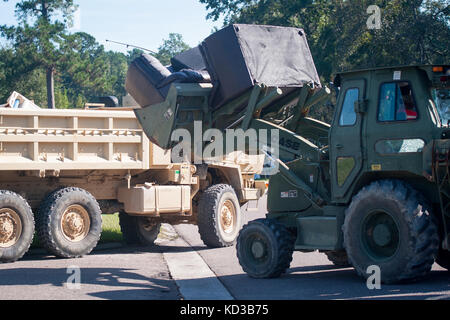 Soldaten in die 1223Rd Engineering Company, South Carolina Army National Guard zugeordnet, Unterstützung für Einwohner der Stadt von summerville mit der Entfernung von haushaltsschmutz okt. 8, 2015. die South Carolina National Guard mit Bundes-, Landes- und lokale Emergency Management Agenturen und Ersthelfer in Reaktion auf Hochwasser bedroht weite im Bereich zusammengeschlossen, um als Ergebnis der starken Regen. (U.s. Army National Guard Foto von Sgt. Brian Calhoun/freigegeben) Stockfoto