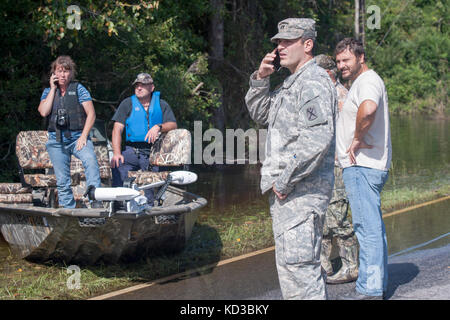 Us-Armee Cpt. John Bryant, Commander, Delta Co.1-118 th Infanterie, s.c. Army National Guard, nimmt einen Anruf von der Williamsburg County Emergency Operations Center (EOC) vor der Vermessung Hochwassergebieten entlang s.c. Highway 41 per Boot in Andrews, S.C. okt. 11, 2015 mit den Mitgliedern des Büros des Williamsburg County Sheriff und ein Vertreter der örtlichen Feuerwehr das South Carolina National Guard aktiviert wurde und County Emergency Management Agenturen und lokalen Ersthelfer als historische Hochwasser zu unterstützen Auswirkungen Grafschaften national. Derzeit mehr als 3.000 Südcarolina na Stockfoto