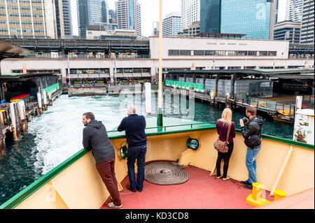 Touristen genießen die Aussicht auf den Hafen von Sydney und die Stadt als sie verlassen den Hafen von Sydney auf dem Weg an Bord der Fähre in einer stürmischen Nachmittag zu Manly Stockfoto