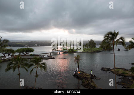 Fischer den ruhigen Wassern der Hilo Bay in der Abenddämmerung mit Blick auf Coconut Island. Stockfoto