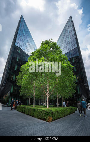 London, England - 17. Juni 2016: Nach oben Bild von Pricewaterhousecoopers in London Bridge City in einem bewölkten Tag mit einem Baum in der Mitte des Stockfoto