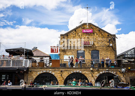 Horizontales Bild von einem Gebäude in Camden Lock an einem sonnigen Tag mit Wolken, Menschen, Restaurants und Geschäften in Londo Stockfoto