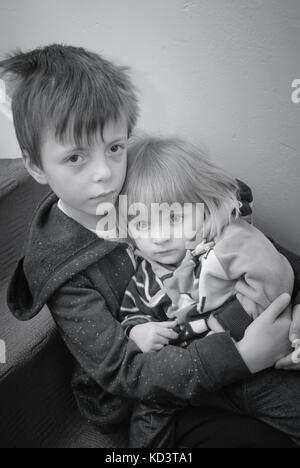 Eine konzeptionelle schwarz-weiß Bild von zwei Geschwister, die eine Reihe von Konzepten wie Armut, Missbrauch, Einsamkeit. Stockfoto