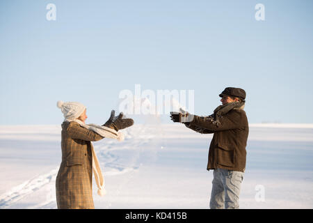 Schöne ältere Frau und Mann auf einem Spaziergang im sonnigen Winter Natur, Schnee genießen und Spaß haben. Stockfoto