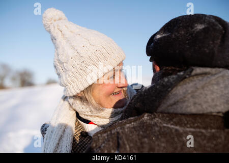 Schöne ältere Frau und Mann auf einem Spaziergang im sonnigen Winter Natur, Schnee genießen und Spaß haben. Stockfoto