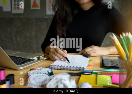 Young Fashion Designer arbeiten mit Stoff Tuch auf dem Holz Tisch Stockfoto
