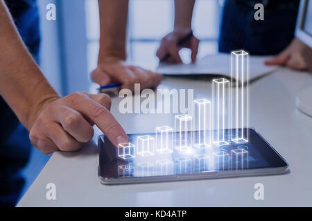 Team von Unternehmen analysiert, 3d-augmented reality Diagramm oben digital Tablet Computer Bildschirm mit wachsenden Ergebnisse und Anlageerfolg, Tech Stockfoto