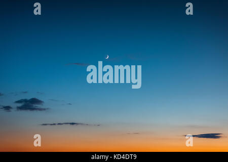 Ein Halbmond und Sterne am Himmel nach Sonnenuntergang Stockfoto