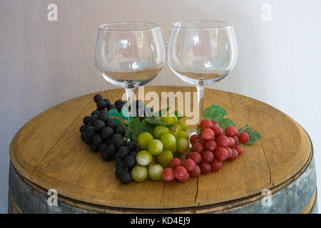 Glas und Rot Weiss Rose Trauben und auf alten Eichenfass Stockfoto