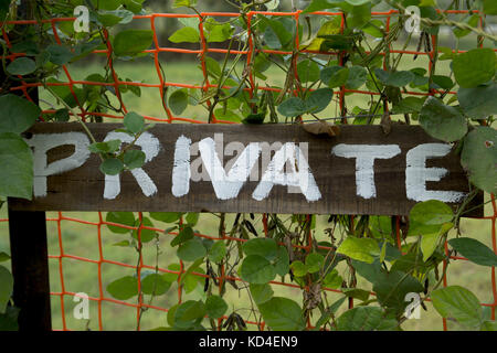 Private Zeichen closeup handgeschrieben auf Block Holz mit Vegetation Stockfoto