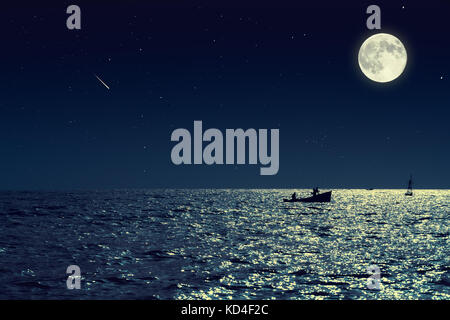 Malerischer Blick auf kleines Fischerboot in ruhigen Meer Wasser in der Nacht und Vollmond. Stockfoto