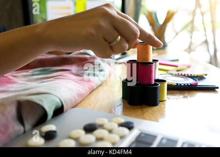 Young Fashion Designer arbeiten mit Stoff Tuch auf dem Holz Tisch Stockfoto
