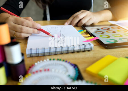 Young Fashion Designer arbeiten mit Stoff Tuch auf dem Holz Tisch Stockfoto