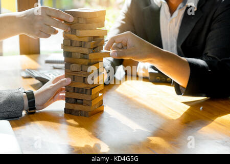 Kaufmann und Kauffrau group Plan und Spiel Jenga Holzkiste Material Holz spiel Konzept für den Test und die Gefahr der Marketingplan vorbereiten Stockfoto