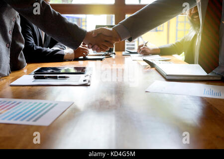 Gruppe der Geschäftsmann Handshake auf Holz Tisch mit Computer Stockfoto