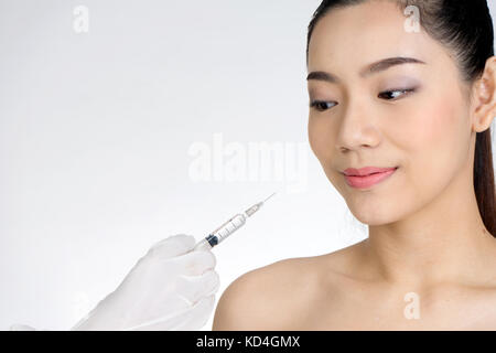 Arzt hand Spritze Injektion zu Frau Gesicht Konzept der Gesundheitsversorgung für die Schönheit die Sie benötigen oder nicht. Stockfoto