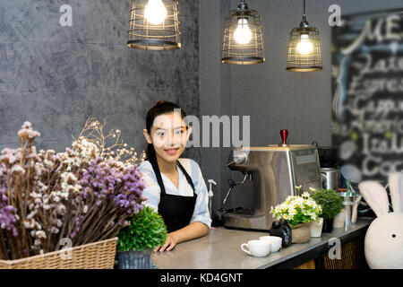 Eine asiatische Frau, in Counter von Café barista und Eigentümer der Shop Stockfoto
