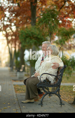 Paar sitzend auf Bank aus Holz Stockfoto