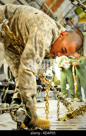 Us-Armee Sgt. Rudy Uribe, ein 19 k, m 1 armor Crewman, sichert eine m1a1 sa Abram mit schweren Ketten an Bord einer C-17 vor dem Flug. Der South Carolina Army National Guard 1-118 th kombinierte Waffen Bataillon (Cab) in schweren Luftbrücke Operationen beteiligt, April 10-11, 2014 at Wright Army Airfield (waaf), hinesville Ga., die Gemeinsame, insgesamt Kraft zu demonstrieren, Fähigkeiten des s.c. army Guard und 315. Der US Air Force reserve airlift Wing. Soldaten und Piloten unisono arbeitete über zwei Tage zu laden und vier neue Die 1-118 th-Cab sa m1a1 Abrams Kampfpanzer auf vier US Air Force sichern Stockfoto