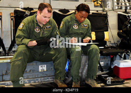 Us Air Force senior airman Robert beschäftigen und Staff Sgt. Ann Roberts führen Berechnungen für die ordnungsgemäße restrainment für 130.000 Pfund m1 Abrams vor dem Flug. Der South Carolina Army National Guard 1-118 th kombinierte Waffen Bataillon (Kabine) beteiligt sich an schweren Luftbrücke Operationen April 10-11, 2014 at Wright Army Airfield (waaf), hinesville Ga., die Gemeinsame, insgesamt Kraft zu demonstrieren, Fähigkeiten des s.c. army Guard und 315. Der US Air Force reserve airlift Wing. Soldaten und Piloten unisono arbeitete über zwei Tage zu laden und sichern Sie vier neue Die 1-118 th-cab M1A1 Abrams main Battle tan sa Stockfoto