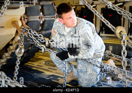 Pfc. Salbei beadling, ein m1 armor Crewman, mit der Th 1-118 kombinierte Waffen Bataillon, sichert eine m1a1 sa Abram mit schweren Ketten an Bord einer C-17 vor dem Flug. Der South Carolina Army National Guard 1-118 th kombinierte Waffen Bataillon (Cab) in schweren Luftbrücke Operationen beteiligt, April 10-11, 2014 at Wright Army Airfield (waaf), hinesville Ga., die Gemeinsame, insgesamt Kraft zu demonstrieren, Fähigkeiten des s.c. army Guard und 315. Der US Air Force reserve airlift Wing. Soldaten und Piloten unisono arbeitete über zwei Tage zu laden und sichern Sie vier neue Die 1-118 th-cab M1A1 Abrams main Schlacht sa ta Stockfoto