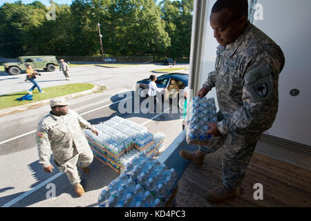 U.S. Army Staff Sgt. William Kee von der 742Nd Wartung Unternehmen, South Carolina Army National Guard, hilft Trinkwasser für die Bewohner von der South Carolina Hochwasser an der unteren Richland High School in Columbia, South Carolina, Okt. 6, 2015 Betroffenen zu verteilen. Das South Carolina National Guard wurde aktiviert und County Emergency Management Agenturen und lokalen Ersthelfer als historische Hochwasser zu unterstützen Auswirkungen Grafschaften national. Derzeit werden mehr als 1.100 Südcarolina Mitglieder des nationalen Schutzes haben in Reaktion auf die Überschwemmungen aktiviert wurde. (U.S. Air National Guard Foto von T Stockfoto