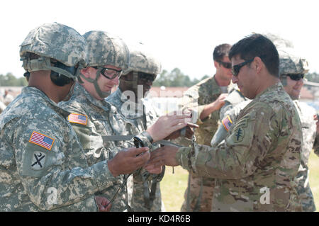 Us-Armee Soldat zugeordnet 7 Special forces Group (airborne) vervollständigt die bolin Knoten zu den sekundären Kabelbaum für ein Soldat der 4. Bataillon zugeordnet, 118 Infanterie Regiment der South Carolina Army National Guard während besonderer Insertion exfiltration System (Spione) Ausbildung bei mccrady Training Center, der eastover, s.c., 17. Mai 2014. Das 7 sfg (a) und die 160 Special Operations aviation Regiment (airborne) eine gemeinsame Mission Training unterstützt rund 100 Soldaten zu 4-118 th in Mrd. während Ihrer scarng bohren Wochenende zugeordnet. (U.s. Army National Guard Foto von Sgt. 1. klasse Ki Stockfoto