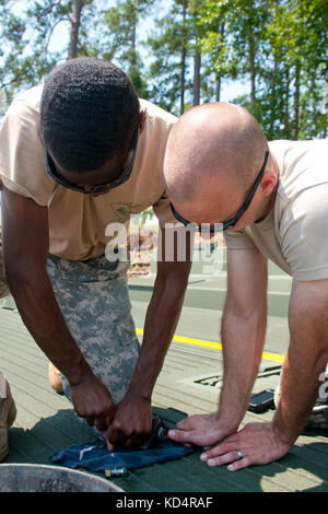 Us-Armee Pvt. 1. Klasse quesley comax (links) und spc. Joshua Collins, 2.BATAILLON, 125 multi-Rolle bridge Company (mrbc), arbeiten zusammen, um eine hydraulische Filter auf eine innere Bucht Abschnitt eines verbesserten ribbon Bridge zu ersetzen als Teil ihrer jährlichen Schulung an der Clarks hill Training Website in Pflaume Zweig, s.c., 17. Juli 2014. Die 125 mrbc hat die Fähigkeit, Brücken, die vorübergehend ersetzen Sie beschädigte oder zerstörte Brücken während der evakuierungen zu helfen oder den Rettungsdienst in ein Gebiet ermöglichen nach einem Wirbelsturm oder anderen Katastrophen errichten. Den 125 mrbc können Brücken über die großen Lücken des Landes bauen und Stockfoto